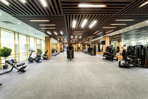- une salle de sport avec des tapis de course et des équipements d'exercice dans un bâtiment dans l'établissement Rixos Turkistan, à Türkistan