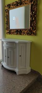 a mirror on a wall above a white cabinet at Hotel Negresco in Milano Marittima