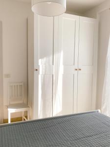 a bedroom with a bed and a white cabinet at La perla del Porto in Porto Recanati