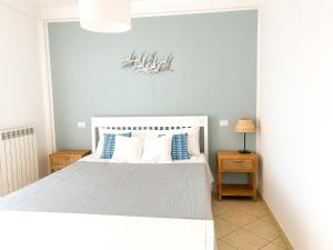a bedroom with a white bed with blue and white pillows at La perla del Porto in Porto Recanati