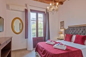 a bedroom with a large bed with red sheets and a mirror at Alcam Books in Barcelona