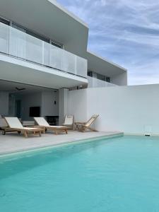 a swimming pool in front of a house at Vila Villaarh in Krk