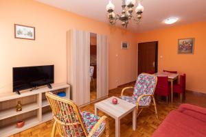 - un salon avec une télévision, une table et des chaises dans l'établissement Casa Oleander, à Crikvenica