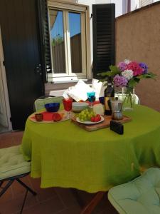 una mesa verde con platos de comida y flores. en Il Casale, en Lucca
