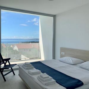 a bedroom with a bed and a large window at Vila Villaarh in Krk