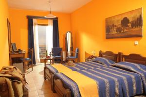 マロニアにあるRoxani Country House Resortのオレンジ色の壁のベッドルーム1室、ベッド1台が備わります。