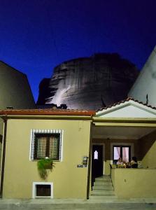 a house with a mountain in the background at Meteora Mary's mansion in Kalabaka