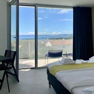 a bedroom with a bed and a view of the ocean at Vila Villaarh in Krk +56 photos