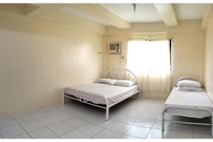 um quarto de hospital com duas camas e uma janela em OYO 800 Ddd Habitat Dormtel Bacolod em Bacolod