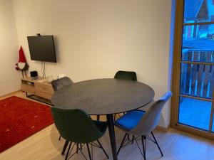 mesa y sillas en una habitación con TV en Apart Vinschgau, en Malles Venosta
