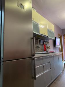 a stainless steel refrigerator in a kitchen with cabinets at Florindas Apartment Qerret in Golem