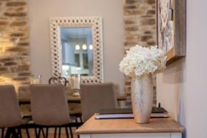 a vase filled with white flowers sitting on a table at Charissa apartment in Volos +54 photos