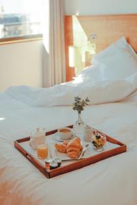 a tray with food and drinks on a bed at Hope Street Hotel in Liverpool