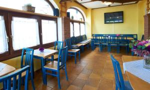 a restaurant with blue chairs and tables and windows at Gästehaus Weinhandl & Johnnys Pizzeria in Podersdorf am See