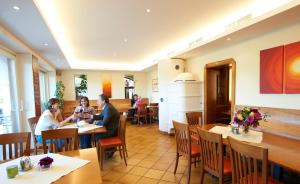 Due persone sedute ai tavoli in un ristorante di Gästehaus Elisabeth Weinhandl a Podersdorf am See Altre 14 foto
