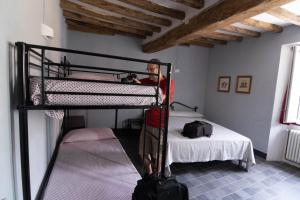 a man standing in a room with a bunk bed at WineBikeHostel in Rocca Grimalda