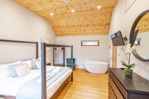a bedroom with a large bed and a bath tub at Thistle Lodge 21 with Hot Tub in Belladrum