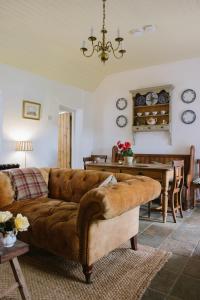 a living room with a brown couch and a table at Keenaghan Cottage Belleek in Belleek