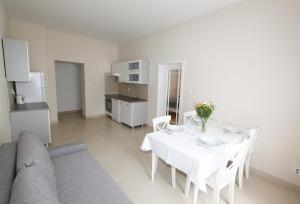 ein weißes Esszimmer mit einem Tisch und einem Sofa in der Unterkunft Rezidence U prince č.1 in Jičín