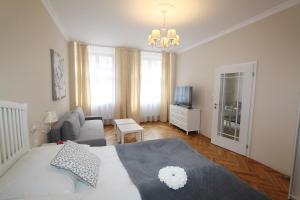 1 dormitorio con cama, sofá y TV en Rezidence U prince č.1, en Jičín
