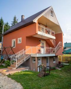 a house with a balcony and stairs on it at Apartments Dedeic in Žabljak