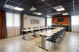 una sala de conferencias con mesas y sillas en una habitación en Best Western Hotelio Montpellier Sud en Montpellier