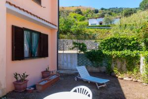 a patio with a blue chair and a window at Appartamento Le Ginestre in Rio nellʼElba