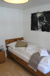a bedroom with a bed with a painting on the wall at Hotel Bären Guttannen in Guttannen