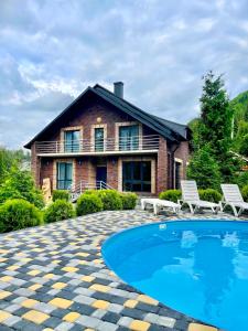 a house with a swimming pool in front of a house at Goral cottage new in Migovo