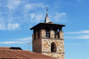 a brick tower with a cross on top of a building at Apartamento acogedor en el centro de Zamora in Zamora