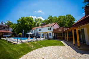 un patio trasero con piscina y una casa en Villa Ruma Dabnishte en Kavadarci