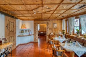 un ristorante con soffitti e tavoli in legno e sedie di Gasthof Alt Paznaun a Ischgl
