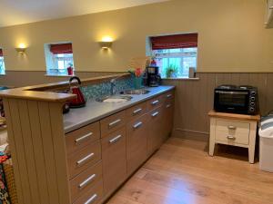 a kitchen with a counter with a sink and a microwave at Coach House, Minting. in Horncastle