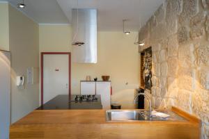 cocina con fregadero y pared de ladrillo en RIBEIRA by YoursPorto, en Oporto