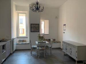 une cuisine avec une table et des chaises ainsi qu'un lustre dans l'établissement Specchio di Parthenope B&B, à Naples