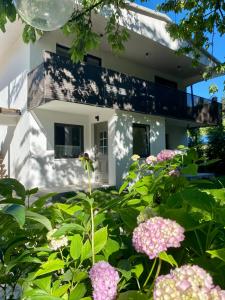布萊德的住宿－Garden Apartments Bled，一座花园,在房子前方种有粉红色的花朵