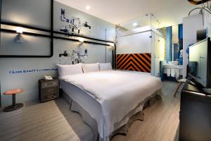 1 dormitorio con 1 cama blanca grande y TV en NL Concept Hotel en Kaohsiung