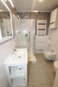 biała łazienka z prysznicem i umywalką w obiekcie Rezidence U prince č.3 w Jiczynie