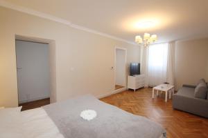 a bedroom with a bed and a couch and a television at Rezidence U prince č.3 in Jičín