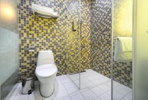 uma casa de banho com um WC e uma cabina de duche em vidro. em NL Concept Hotel em Kaohsiung