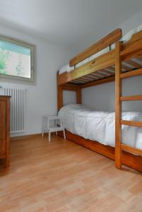 馬東納迪坎皮利奧的住宿－Baita Carlo Magno，一间卧室设有两张双层床和一扇窗户。