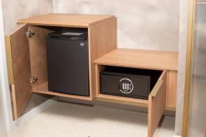 a small wooden cabinet with a black appliance in it at Hotel Faro Lariño in Lariño +73 photos
