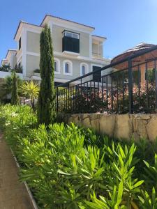 ein weißes Haus mit einem Zaun und einigen Pflanzen in der Unterkunft Cozy 4 Room Ap with Whirlpool,3min drive to the beach in Bahia de Casares