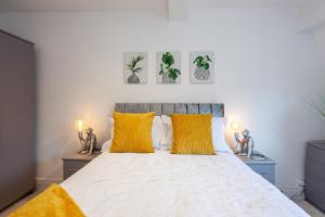 a bedroom with a large bed with yellow pillows at Cosy 2 Bed Apartment - Close to Leeds Centre in Moortown