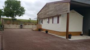 a small white building with a driveway next to it at Mobile-home in Braucourt