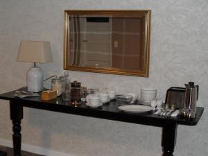 una mesa con platos y un espejo en la pared en B&B Manderscheid-Blick, en Pantenburg