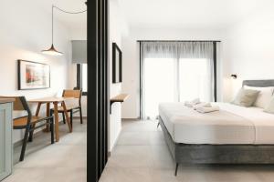 a bedroom with a bed and a dining room at Cove Suites in Iraklitsa +44 photos