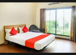 a bedroom with a large bed and a large window at Hotel Relax Inn in Nagpur
