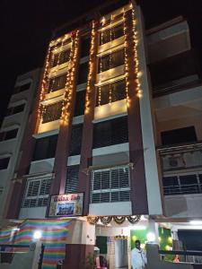 un edificio alto con luces encendidas por la noche en Hotel Relax Inn, en Nagpur