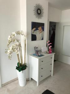 um quarto com uma cómoda e um vaso com flores em Penthouse - Sunset Dream em Uhldingen-Mühlhofen